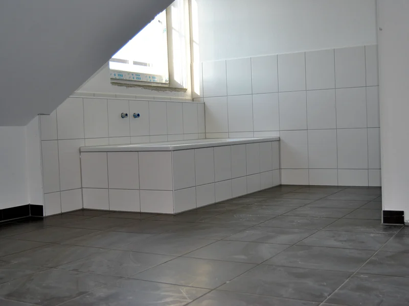 Frisch verflieste Wand und Boden in einem Bad unter der Dachschräge