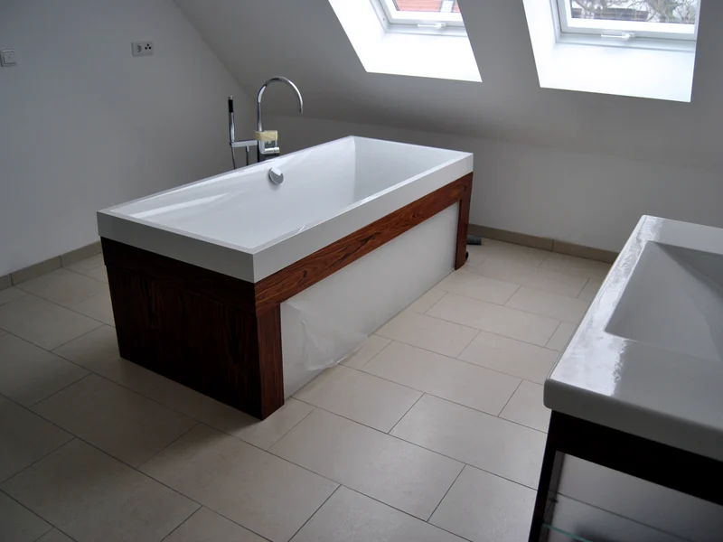 Badezimmer mit freistehender Wanne in Holzverkleidung unter einer Dachschräge