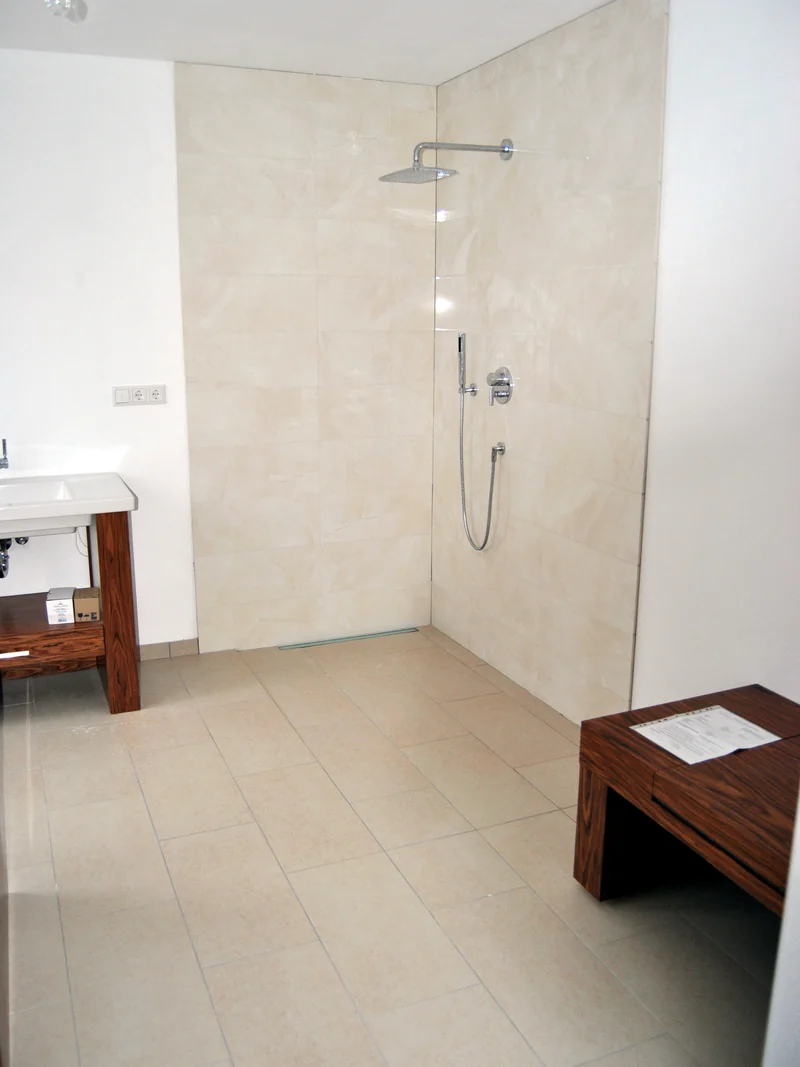 Bodengleiche Dusche mit hellen großformatigen Wandplatten